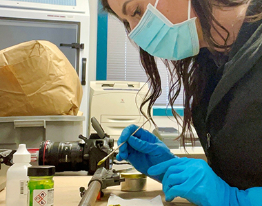 Forensic Specialist examining a piece of evidence.