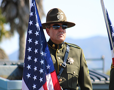 Honor Guard member standing holding American Flag.
