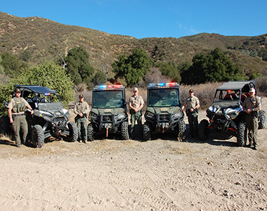 Off Highway Vehicle members standing with four Sheriff's Office off-road vehicles.