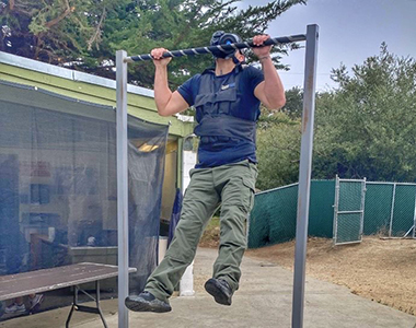 Correctional Deputy doing a pull-up wearing a gas mask.