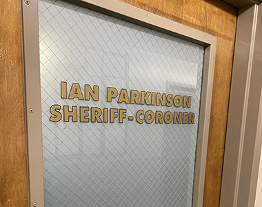 Closed door with wording "Ian Parkinson Sheriff-Coroner"