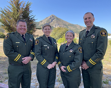Custody Executive Staff smiling forward with a mountain in the background.