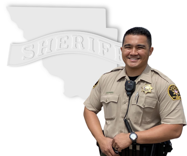 Correctional Deputy standing in front of a white outline of San Luis Obispo County with a banner reading "Sheriff."