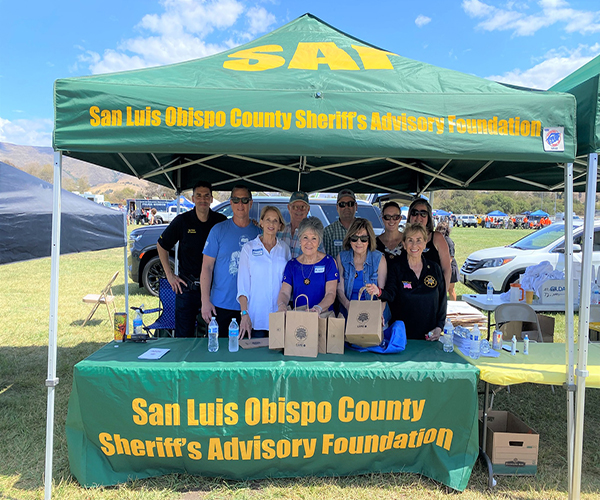 Sheriff's Advisory Foundation members standing behind a booth at a community event.