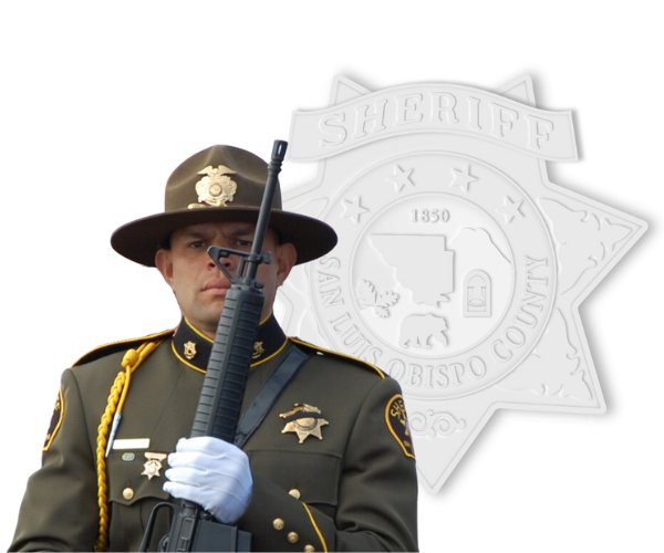Honor Guard member holdig a gun standing in front of a white Sheriff's Office badge.