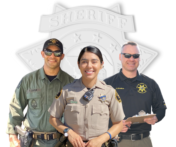 Three patrol staff smiling in front of a stylized white Sheriff's Office badge.